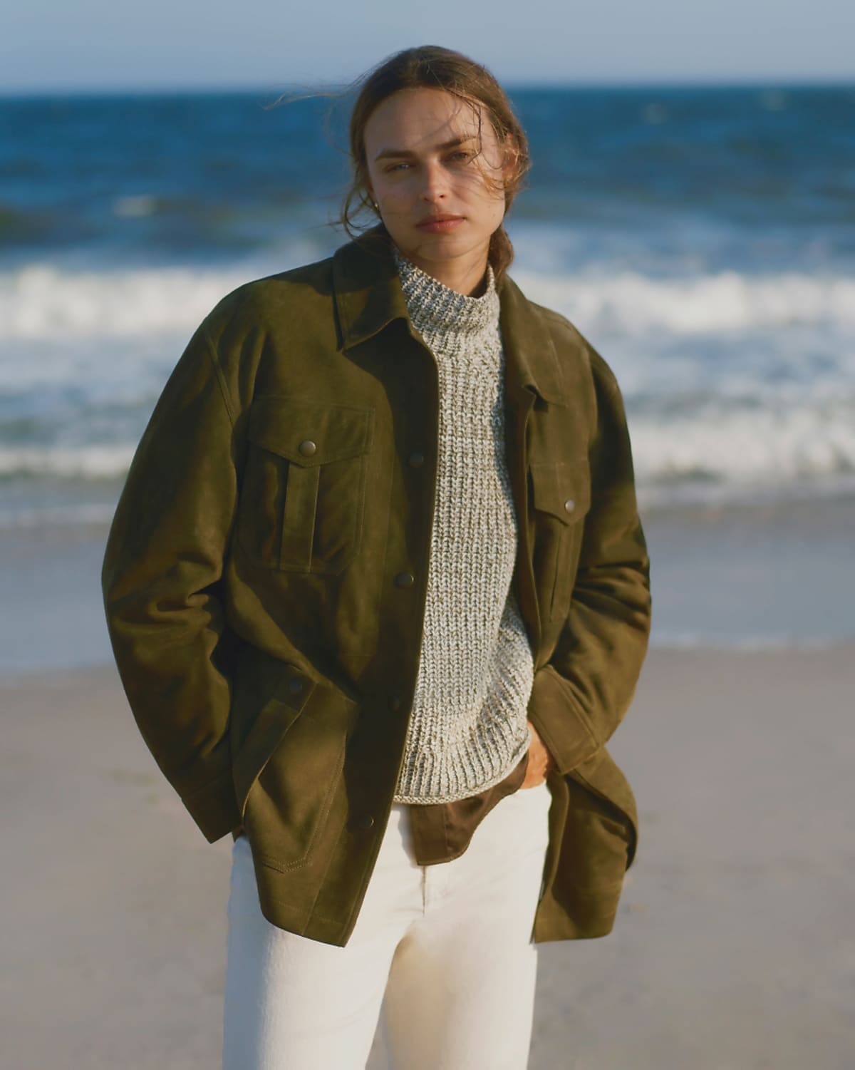 man standing in front of a parachute with classic beige shorts, white top, and a beige shirt