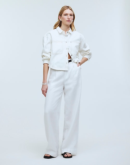 White linen pants with green top and gold statement necklace and